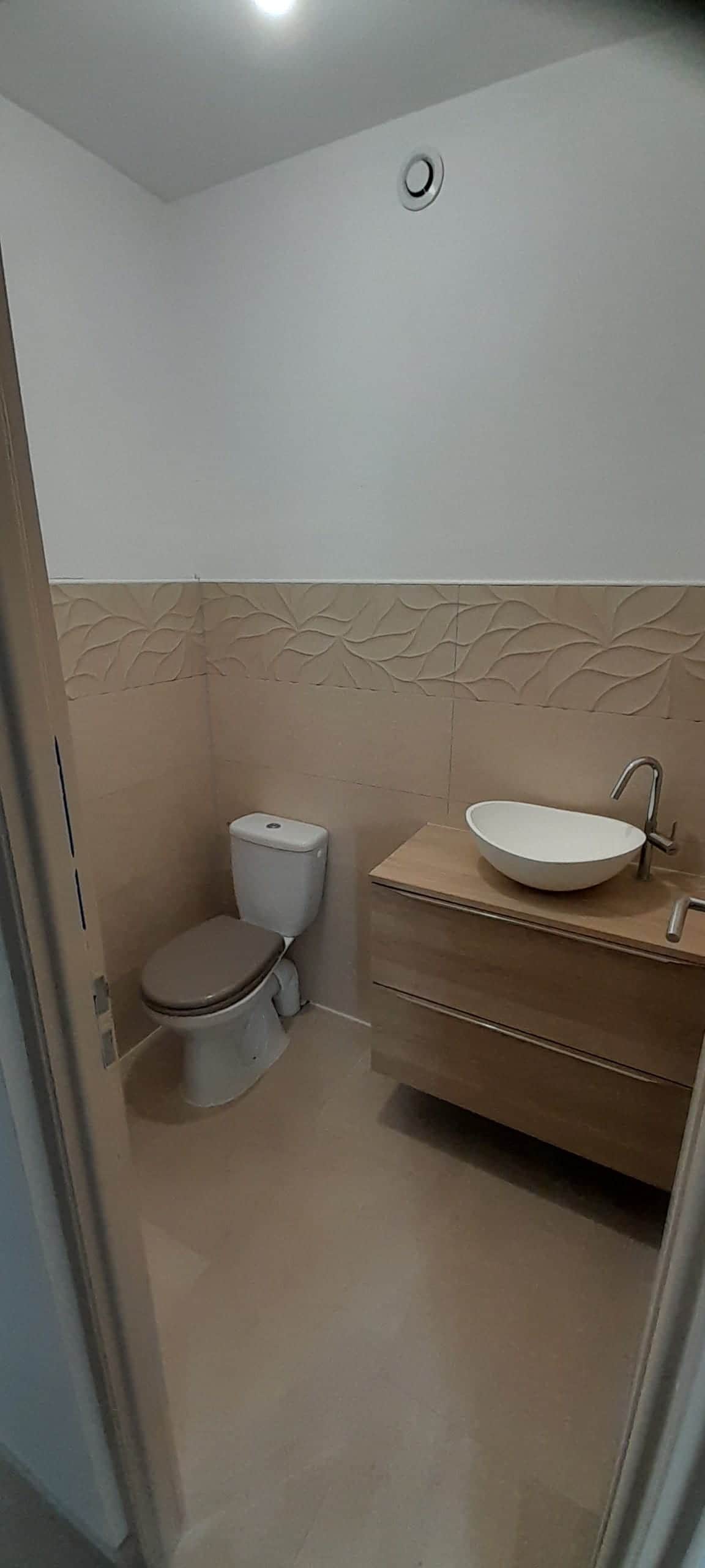 WC et meuble bois avec vasque à poser, faïence beige en relief posée à mi-hauteur